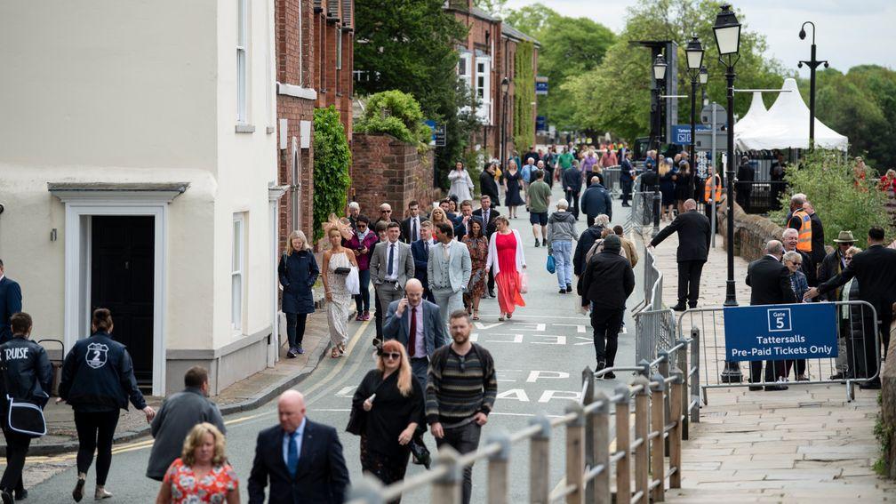 Racegoers make their way to the Roodee along the city walls on Chester's opening day
