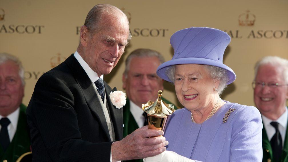 The Queen is presented with the Queen's Vase by the Duke Of Edinburgh after Estimate's win in 2012