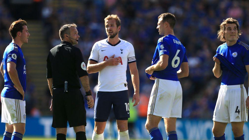 Referee Paul Tierney speaks with Harry Kane during the Premier League match between Leicester City and Tottenham Hotspur