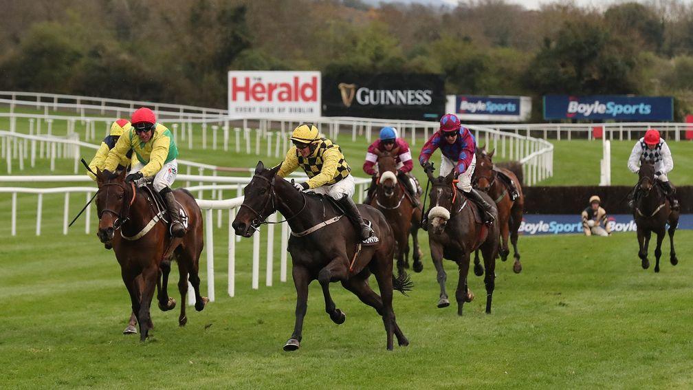 Paul Townend begins to steer Al Boum Photo (centre) around the final fence in the Growise Champion Novice Chase at Punchestown in 2018