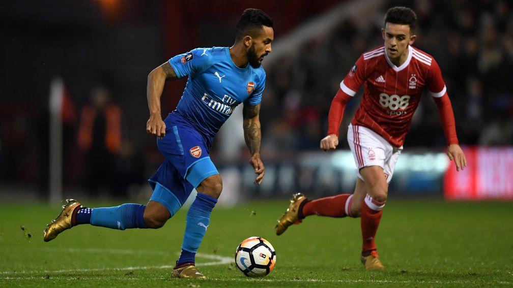 Theo Walcott carries the ball past Zach Clough of Nottingham Forest