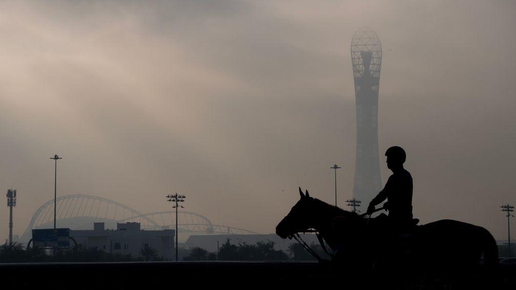 Khalifa International football stadium and The Torch provide a backdrop to Al Rayyan racecourse on a misty morning