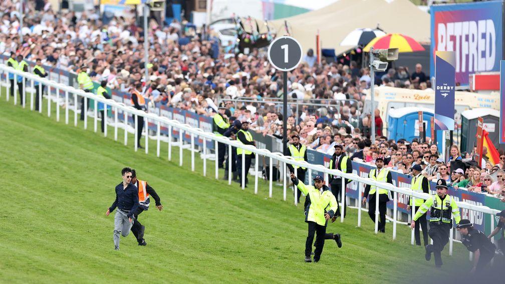 A protester runs on to the race track but is arrested as he fails to disrupt the Betfred Derby
