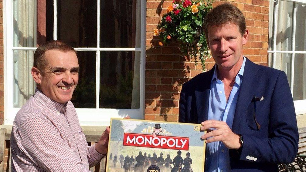 David Milnes presents Qatar Racing manager David Redvers with a signed edition of Newmarket Monopoly, which he auctioned to raise money for Allan Mackay