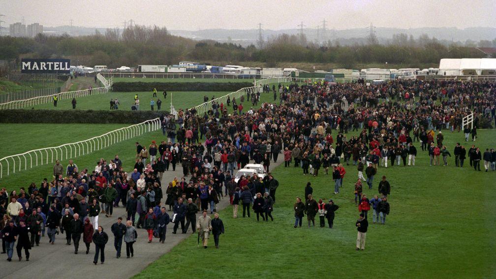Crowds make their way to an exit on the far side of the Aintree course near Canal Turn after the 1997 bomb scare
