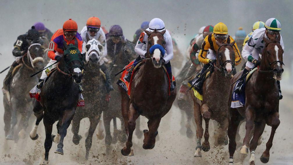 Justify (blue noseband, middle) sits just outside leader Promises Fulfilled (right) as the field heads into the first turn in the Kentucky Derby