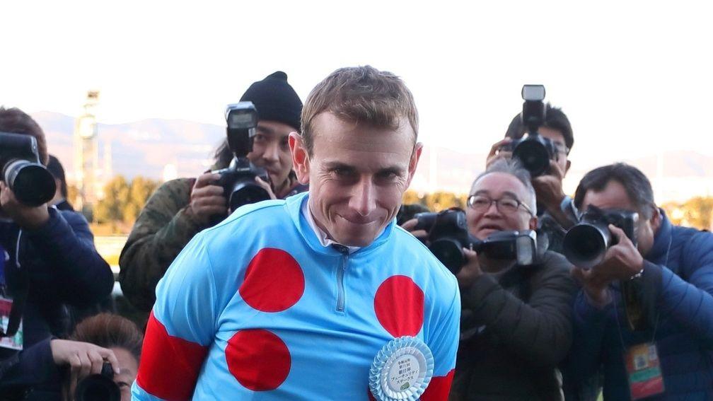 Ryan Moore is surrounded by photographers at Hanshin after winning the Grade 1 Asahi Hai Futurity aboard Salios