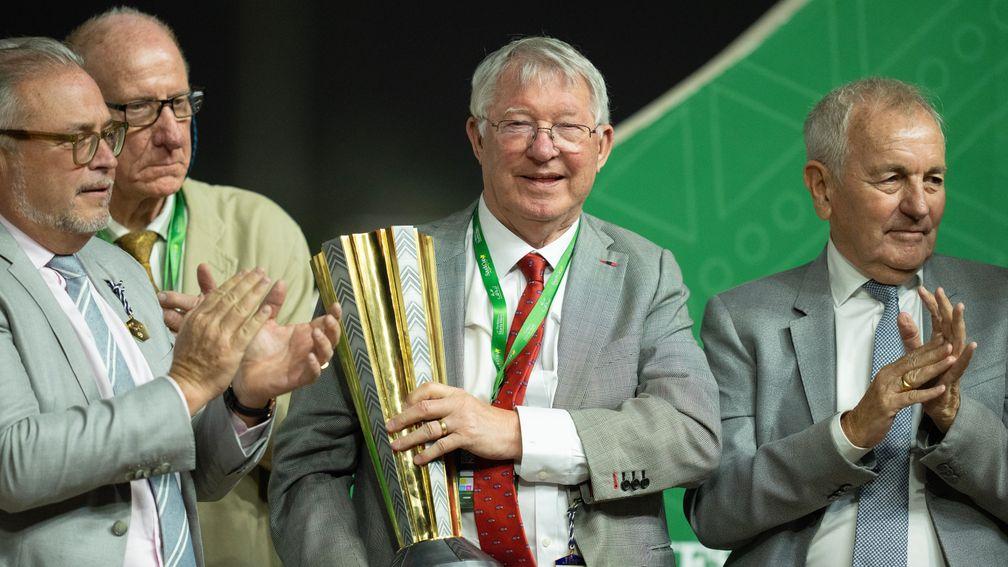 Sir Alex Ferguson (centre), Jed Mason (right) and Peter Done with the Neom Trophy after Spirit Dancer's win