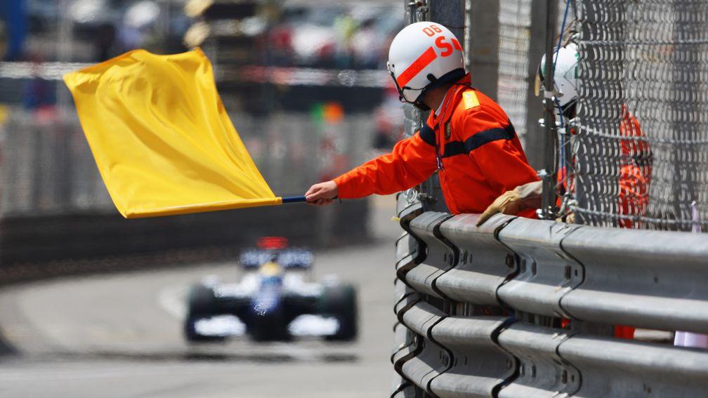 A marshall waves a yellow flag at the Monaco Grand Prix