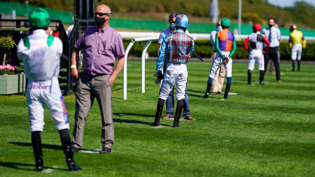 NEWCASTLE UPON TYNE, ENGLAND - JUNE 01: Social distancing in the parade ring by the jockeys at Newcastle Racecourse on June 01, 2020 in Newcastle upon Tyne, England. Horseracing resumes today for the first time since March 17th as the government relaxes s