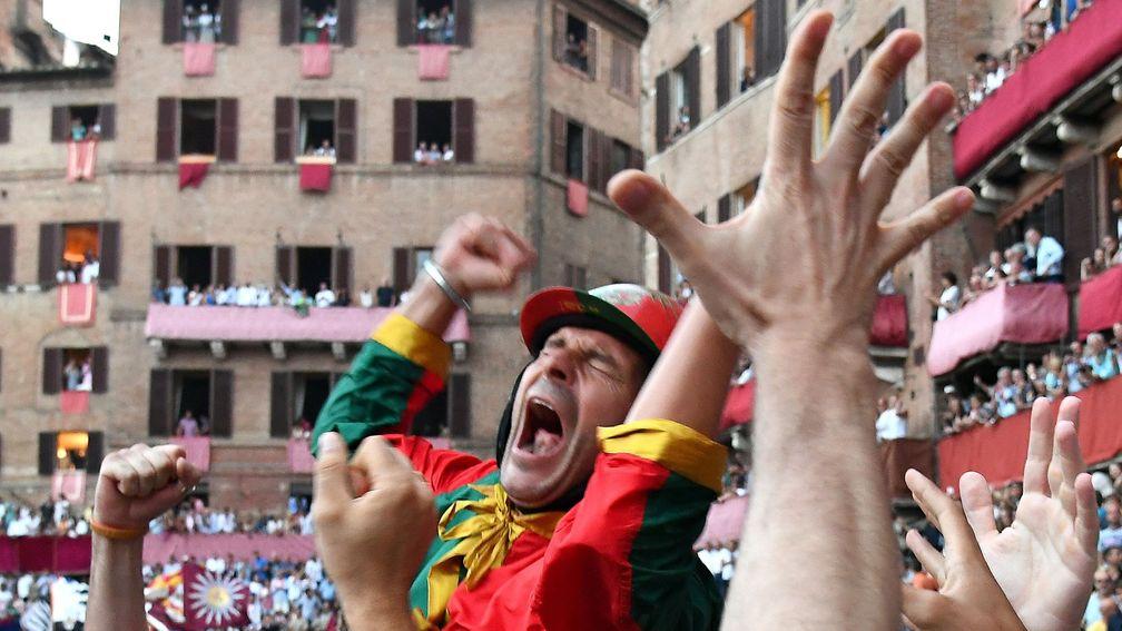 The winning Palio jockey is swamped by delirious supporters
