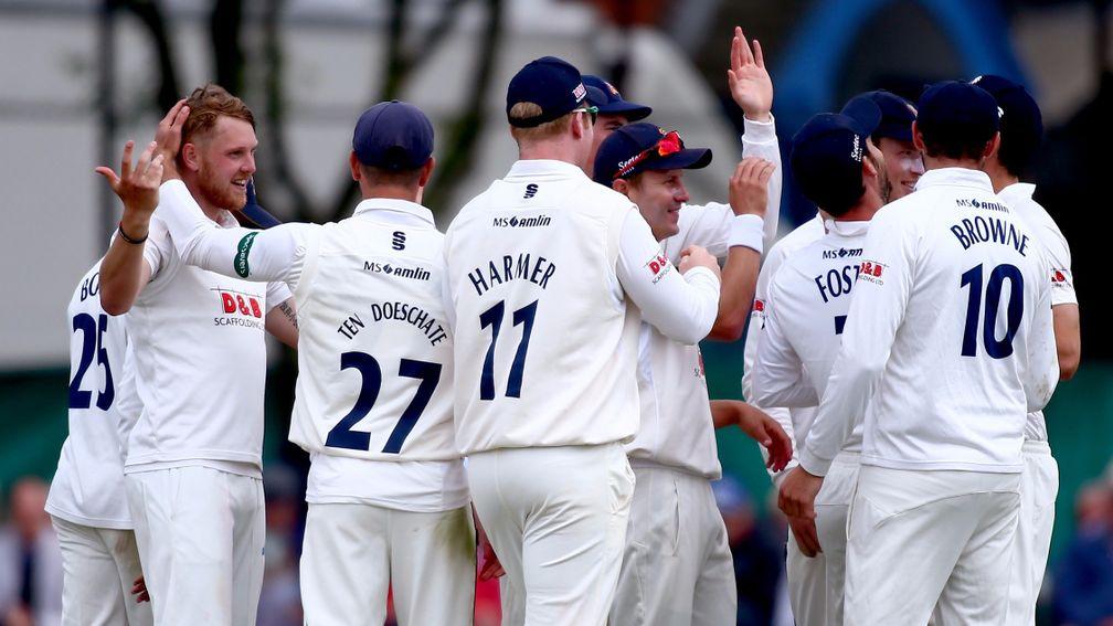 Jamie Porter (left) and his Essex teammates celebrate a wicket against Surrey