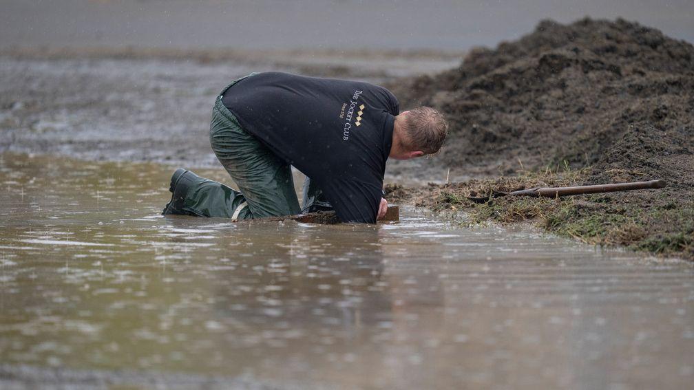 Staff of KJockey Club estates desperately try and clear the floods created by torrential rain at the bottom of Warren Hill gallopsNewmarket 25.8.22 Pic: Edward Whitaker