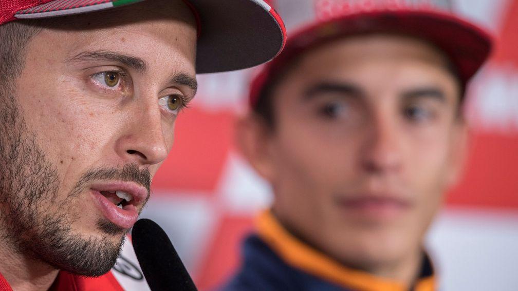 Andrea Dovizioso speaks to the press while Marc Marquez watches