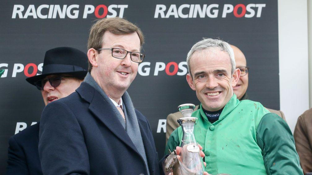Racing Post chief executive and editor in chief Alan Byrne presents Footpad's rider Ruby Walsh with his trophy for winning the Racing Post Arkle Chase