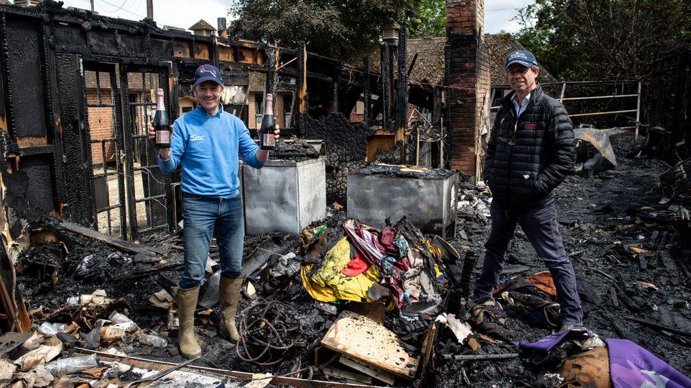 Trainer Jamie Osborne surveys the remains of the fire that devasted a bungalow at his Old Malthouse stables in Upper Lambourn. His assistant Jimmy McCarthy holds up 2 bottles of Champagne that survived the blaze 8.6.19 Pic: Edward Whitaker