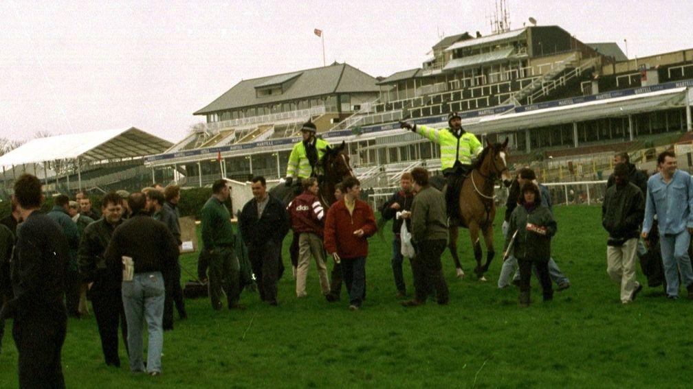 The final few spectators are told b y police to leave Aintree racecourse