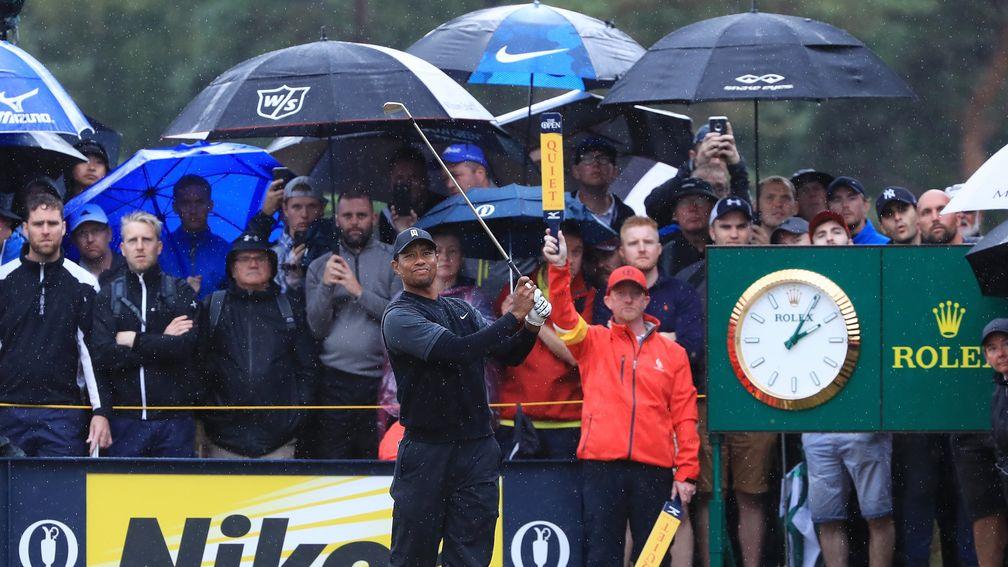 Enthusiastic spectators brave the weather to watch Tiger Woods tee off at the 14th