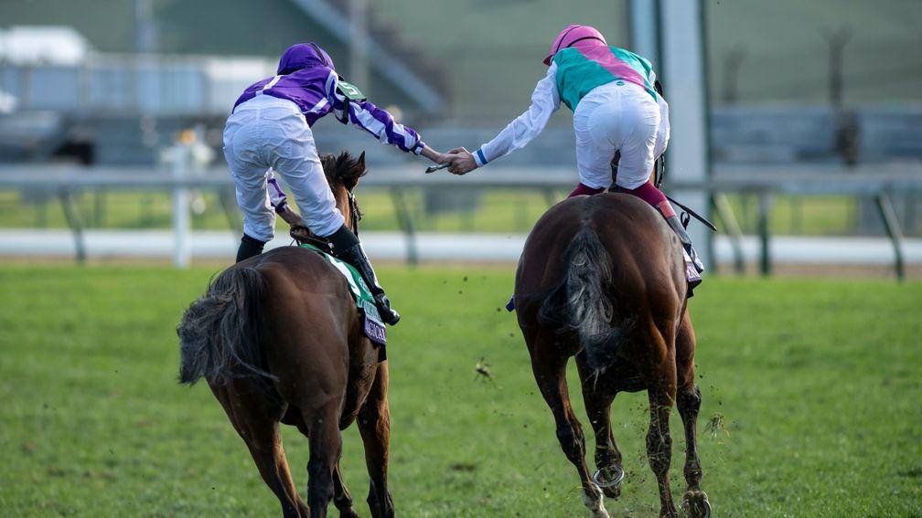 Frankie Dettori and Ryan Moore hold hands after Enable's victory in the Breeders' Cup Turf