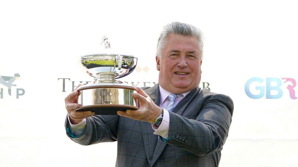 Paul Nicholls holds his champion trainer's trophy aloft, which he was winning for the 13th time
