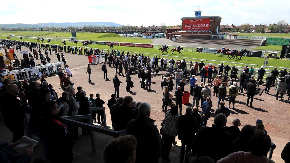 REDCAR, ENGLAND - MAY 17: Racegoers watch on as Grangeclare View ridden by jockey Tony Hamilton wins the Great To Welcome You Back Median Auction Maiden Stakes at Redcar Racecourse on May 17, 2021 in Redcar, England. (Photo by Mike Egerton-Pool/Getty Imag